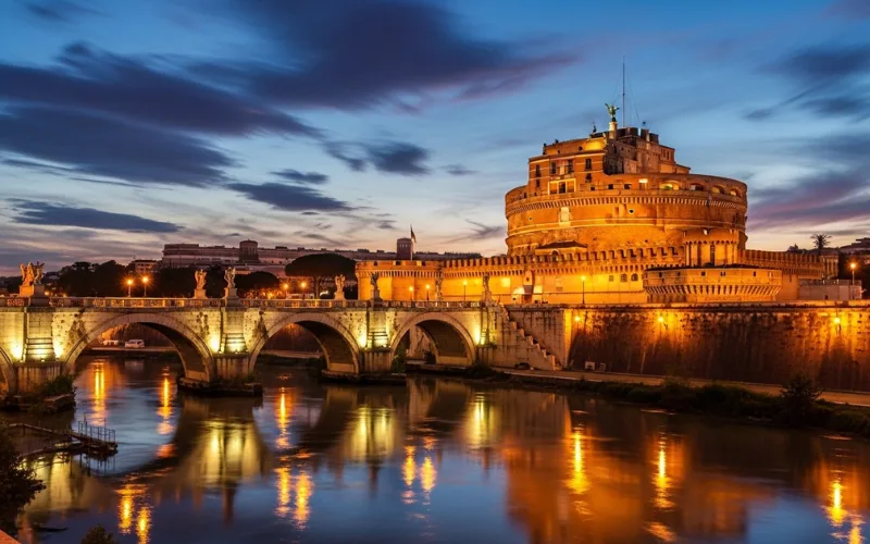 Castel Sant’Angelo at twilight with glowing lights reflected on Tiber River