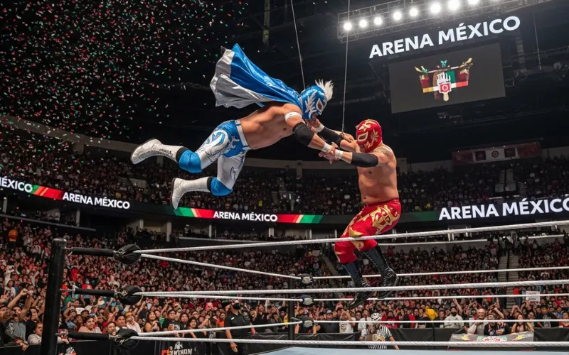 Masked lucha libre wrestlers performing dramatic jump 
